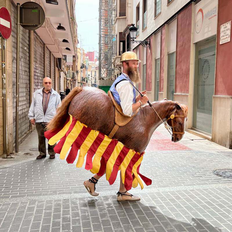 Un cavallet del Corpus passant pel carrer sota l’atenta mirada d’un transeünt.